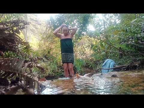 Young girl bathing in natural water source