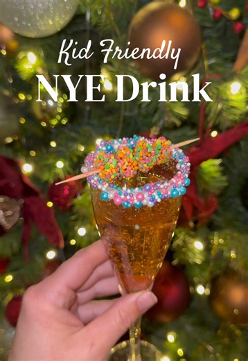 Kid Friendly NYE Drink 🥂 My first mom hack is to always use plastic cups! Dip the cups in icing and sprinkles on the rim. Next, add cotton candy and sprite or seltzer water. I garnished the cup with my kids’ favorite, nerd clusters! Enjoy the sugary mocktail 😅🪩🍾 #nye #toddleractivities #momsoftiktok #momlife #mocktail