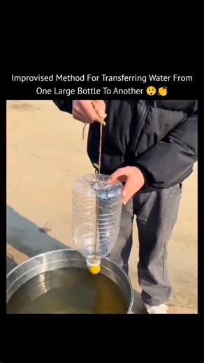 The Explainer on Instagram: "This post captures a simple, improvised method for transferring water from one large bottle to another using a smaller bottle and a string. A smaller plastic bottle has its bottom removed and is inverted into the opening of a larger bottle. A string runs from the bottom of the inverted bottle into the water of the larger bottle below. This setup creates a siphon effect, allowing water to flow from the top container to the bottom one without spills. It is a practical 