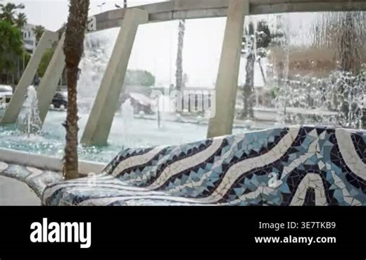 Mosaic tiled bench in foreground with defocused fountain and soft bokeh plaza background; background backdrop copyspace template Stock Video Footage - Alamy