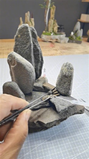 Artwork Unity on Instagram: "A quiet mountain world, built stone by stone 🌿 This miniature landscape is handcrafted from natural rock, layered with patience and intention. Tall weathered peaks rise from a grounded base, connected by worn steps and soft paths of moss. Subtle details invite the eye to wander and slow down, like a pause in time where nature and imagination meet 🪨 Each piece is composed by hand, balancing weight, texture, and negative space to capture the feeling of a vast landsca